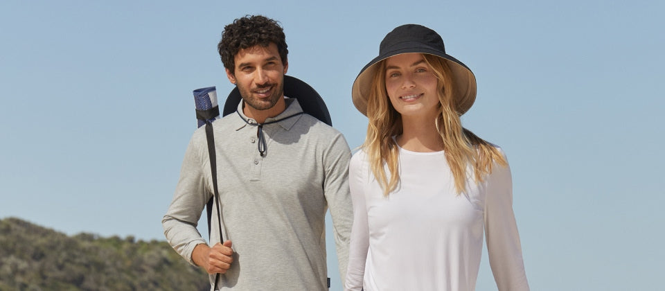 Two people standing outdoors wearing Solbari sun hats and clothing