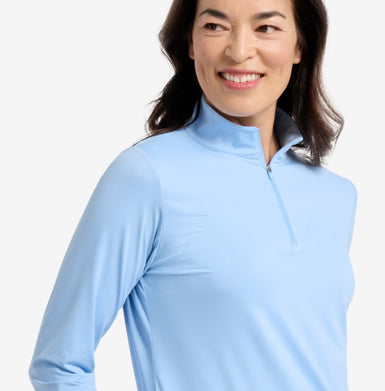 Woman wearing a light blue long-sleeve shirt with a high collar on a white background